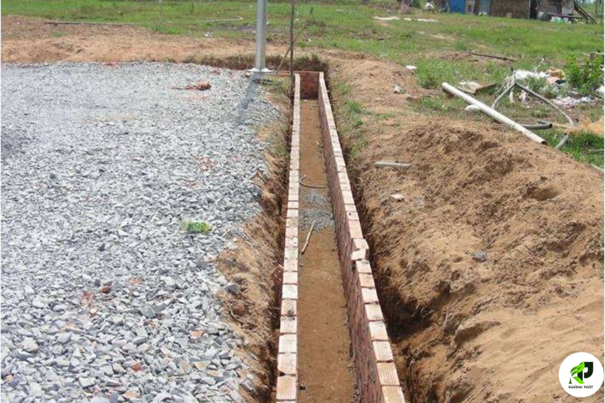Hệ thống thoát nước sân 11 người — phương pháp mái 4 phía, dốc 0,6–0,8% từ giữa ra 2 biên dọc và 2 biên ngang